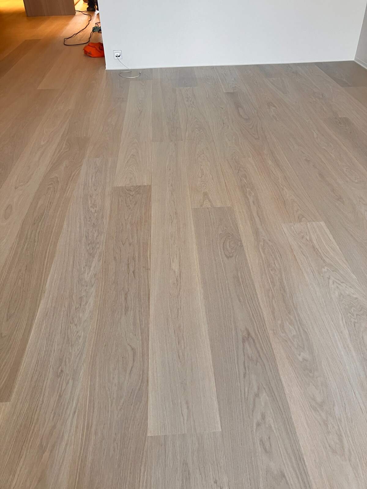 Parquet clair à larges lames posé et fini dans une pièce lumineuse