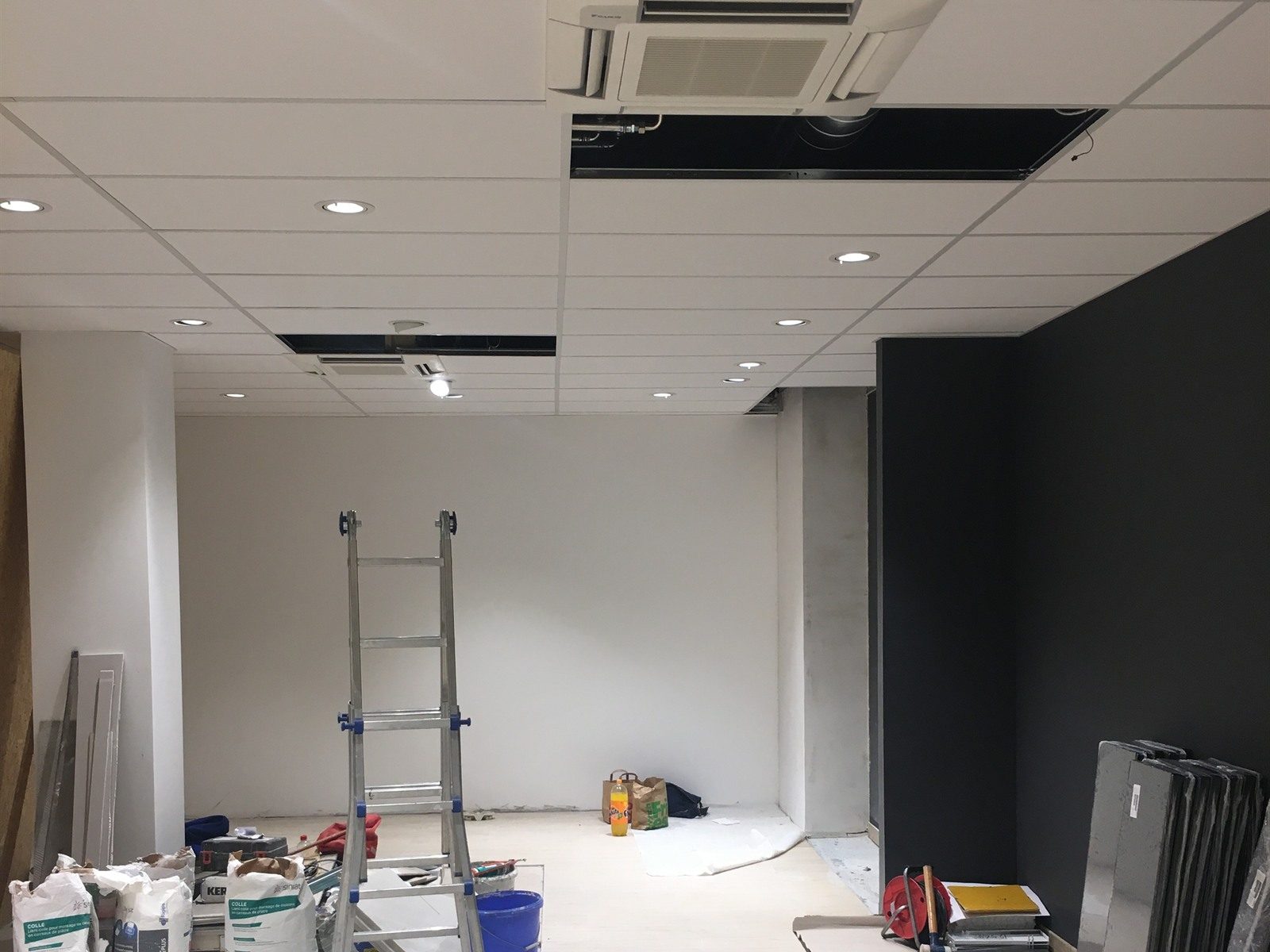 Faux-plafond à dalles d'un local commercial à Genève avec spots encastrés et cassette de climatisation